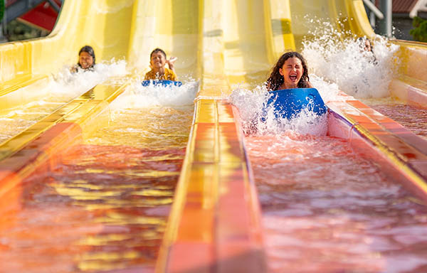 Children sliding and laughing on waterslide